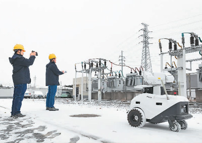 寫真：安徽省亳州市の変電所で2日、電力供給設備の點検を行う5Gスマートロボットと運用保守要員。撮影?梁西海